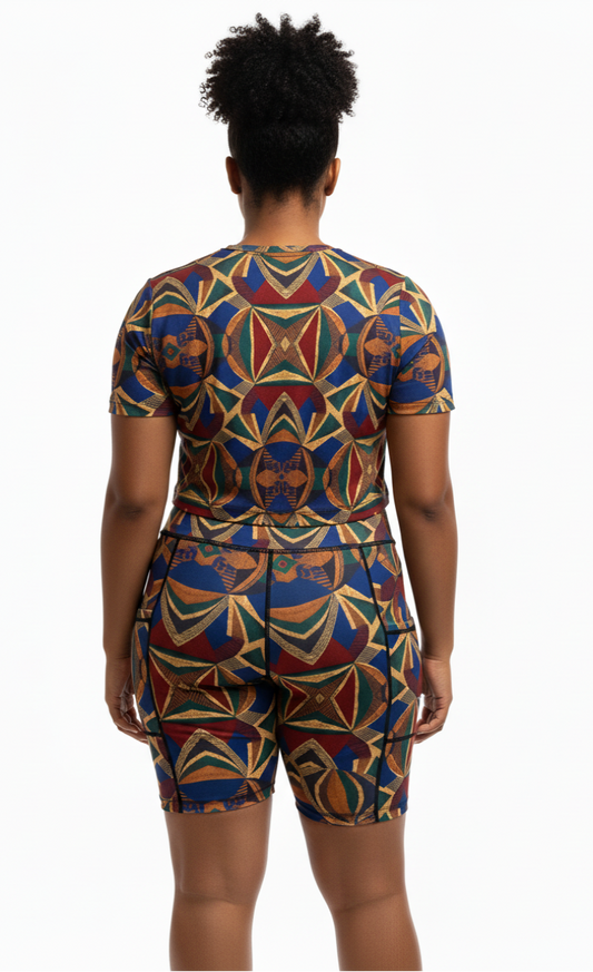 Person wearing a colorful geometric ankara patterned outfit on a white background